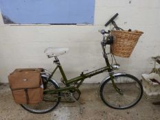A Raleigh stowaway ladies bike with basket panniers and pumps