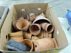 A box of various terracotta plant pots and a wirework squirrel model