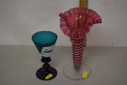 A cranberry and swirled glass vase together with a turquoise wine