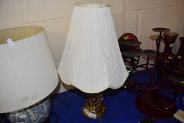 A brass table lamp and cream shade