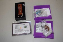 Three gemset keyrings and a loose gemstone: to include a three stone dark blue sapphire and