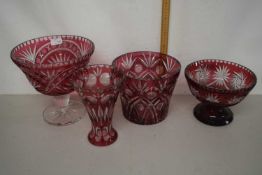 A group of four 20th Century Bohemian cranberry and clear cut glass vases of various designs