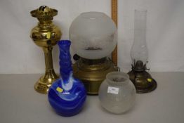 Mixed Lot: Three various brass based oil lamps and a further blue glass vase