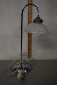 A chrome desk lamp with frosted glass shade