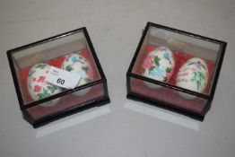 Two cased ceramic eggs painted in Asian style