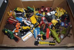 Box of various toy vehicles and toy dinosaurs