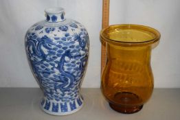 A reproduction Chinese blue and white dragon patterned vase together with a further amber glass vase