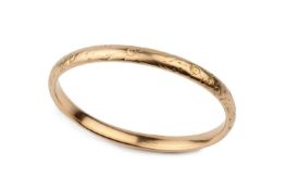 A 14k gold oval bangle, engraved with stylised flowers, stamped 14K, 7.5cm wide Approx 20.2g.