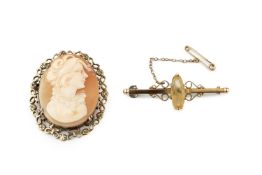 A 15ct gold and citrine bar brooch, the marquise cut stone set to a bar with scrolling shoulders,