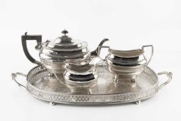 An Edwardian silver three piece tea service, with gadrooned borders, the teapot with ebonised handle