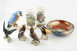 A Goebel porcelain figure of a parrot, with blue and orange plumage, perched upon a foliate