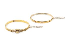 A late Victorian diamond and seed pearl set hinged bangle, the central diamond set within a