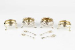 A pair of George II silver salts, of circular form with florally embossed decoration, on stepped pad