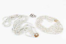 A triple strand freshwater pearl long necklace, the pierce-decorated 14k gold clasp of flowerhead