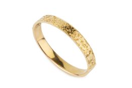 A 15ct gold oval hinged bangle, engraved with scrolling foliage, 6.3cm wide Approx 14.1g