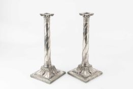 A pair of 19th century silver plated candlesticks, with corinthian capitals, the square bases relief
