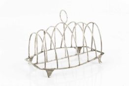 A George III silver seven bar toast rack, of arched wirework form, on shaped feet by Stephen Adams