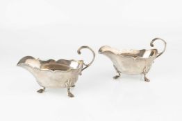 A pair of Continental silver sauce boats, possibly Hanau, with shaped borders, scroll handles and