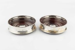 A pair of modern silver bottle coasters, with turned hardwood bases by Carr's, Sheffield 1998, 12.