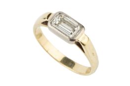 A diamond solitaire ring, the emerald cut stone collet set to an unmarked yellow metal shank Ring