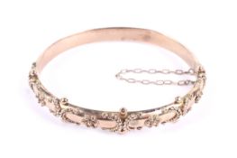 An Edwardian 9ct rose gold fancy hollow hinged bangle.