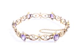 An Edwardian gold, amethyst and half-pearl open bracelet.