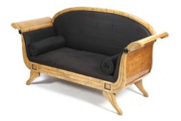 A Biedermeier style satinwood boat shaped sofa settee.