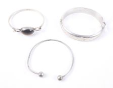 Two vintage silver bangles and a silver-plated torque bangle.