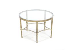 A circa 1970s round brass coffee table with glass top.