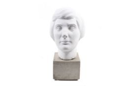 A white painted concrete sculpture of a head of a woman. With a square stand, height of head 26cm.