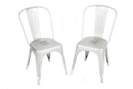 Two Tolix style pressed metal staking cafe chairs.