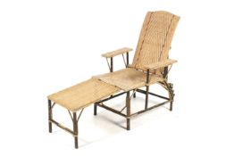 A mid-century plantation style rattan and beech branch framed lounger chair.