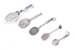 Five 'Wimbledon' tennis brooches and pendants. One marked 'silver', 2.