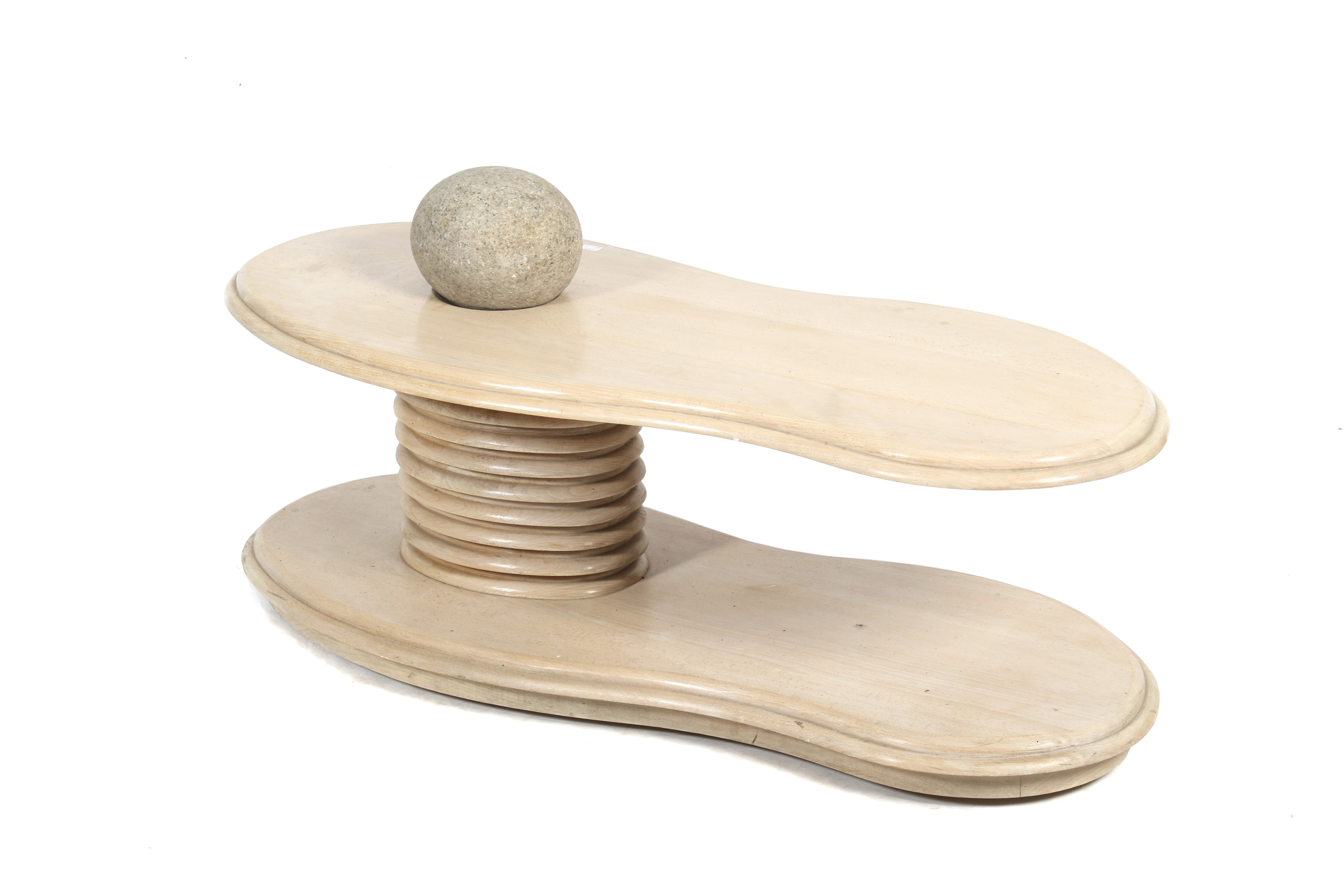 A contemporary single pedestal blonde oak coffee table with large pebble.