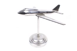 Chrome desk model of a Boeing 747 Jumbo jet plane in flight.
