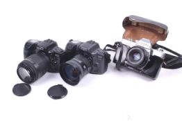 Three Minolta 35mm SLR cameras.