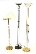 Three contemporary standard lamps. Comprising one with a brass frame and glass shade, H181.