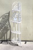 A white painted metal folding corner plant stand.