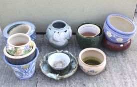 Thirteen glazed garden pots, stands and dishes. Some with pierced and handpainted decoration. Max.