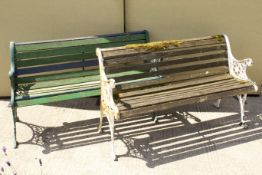 A pair of slat-back garden benches. With cast iron open scroll end supports and legs.