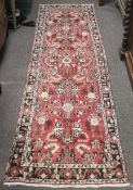 A 20th century Iranian red ground wool runner rug.