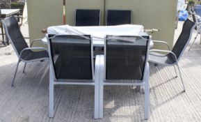 A set of six garden chairs, a rectangular table and a parasol.