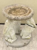 A reconstituted stone 'Pelican' bird bath in the form of a shaped round bowl on three pelican