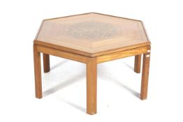 A contemporary hexagonal brass parquetry inlay coffee table. Raised on six chamfered supports.