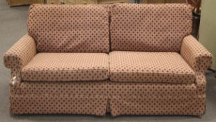 A red upholstered three seater sofa.