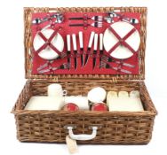 A vintage wicker picnic basket and contents.