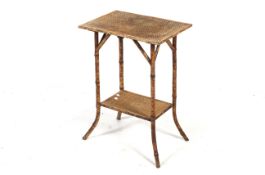 A Victorian bamboo framed two-tier side table.