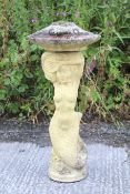 A cast reconstituted stone bird bath in the form of a mermaid and a shell.