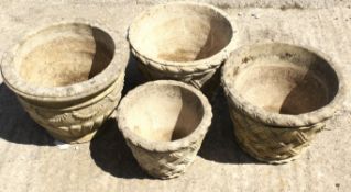 Four reconstituted stone garden pots.