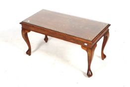 A contemporary brass inlay mahogany coffee table with a glass top.